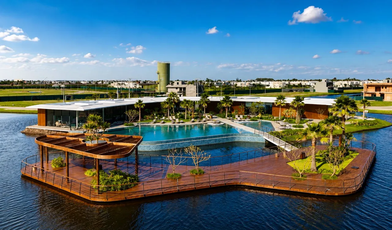 Clube com piscina e deck flutuante sobre o lago de um condomínio no litoral norte